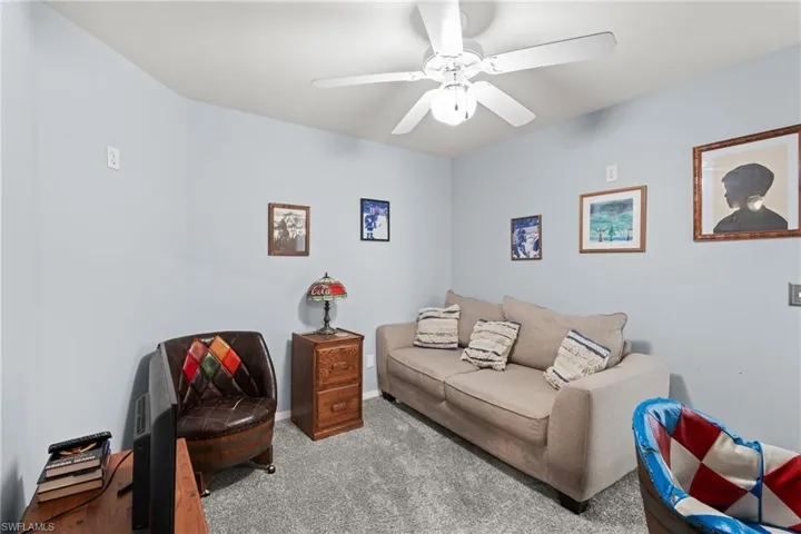 Living room with light colored carpet and ceiling fan