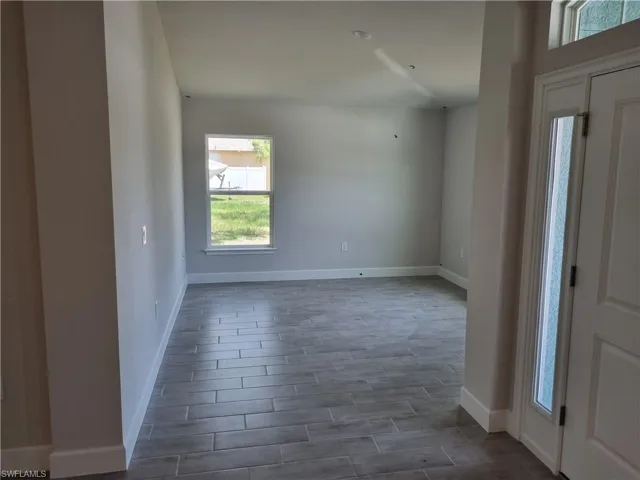 Foyer entrance featuring baseboards and dark wood-style floors
