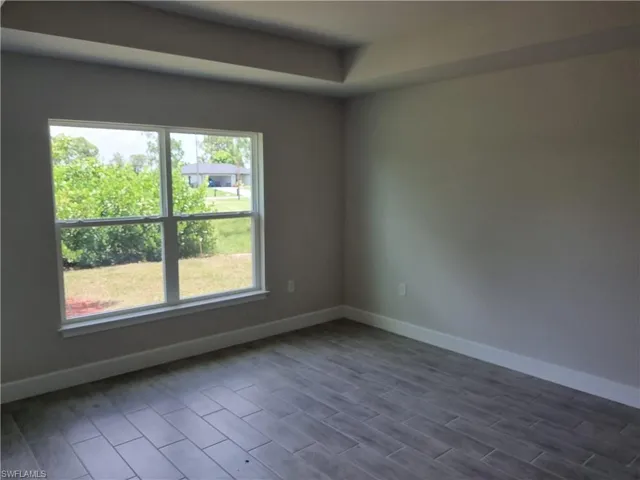 Unfurnished room featuring dark wood-style floors