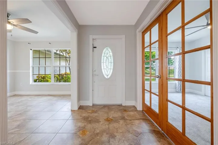 Foyer with light tile patterned flooring, french doors, and ceiling fan