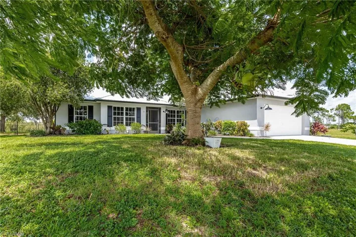 Ranch-style house with a garage and a front lawn