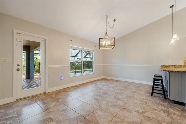 Unfurnished dining area featuring an inviting chandelier and light tile patterned floors