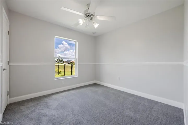 Empty room with carpet flooring and ceiling fan