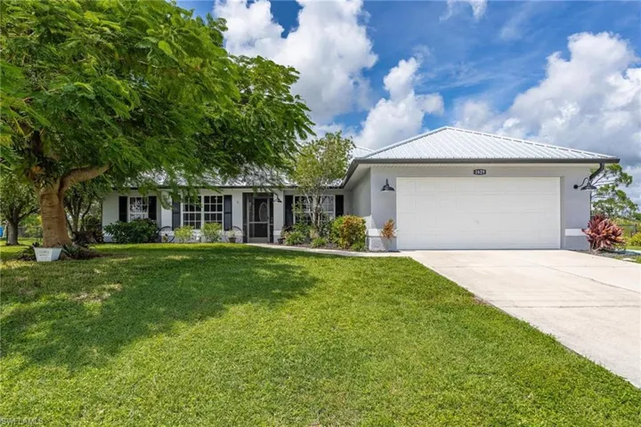 Ranch-style home with a garage and a front lawn