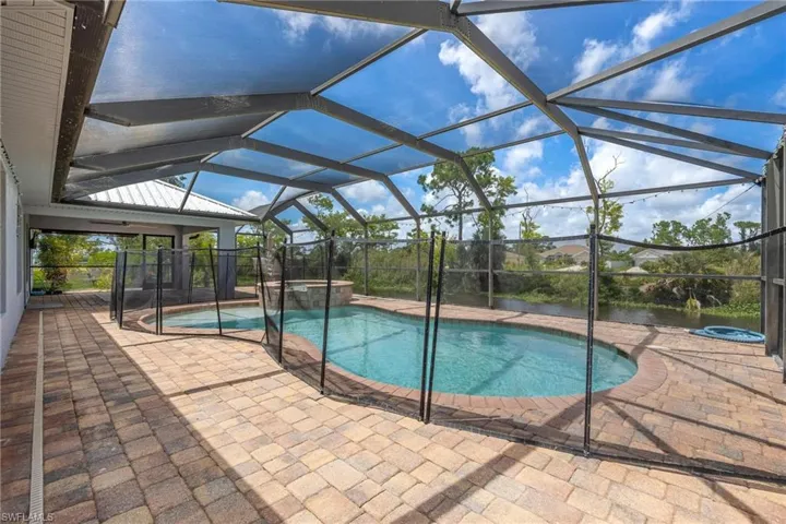 View of swimming pool featuring a patio and glass enclosure