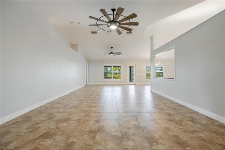 Unfurnished living room featuring ceiling fan and light tile patterned floors