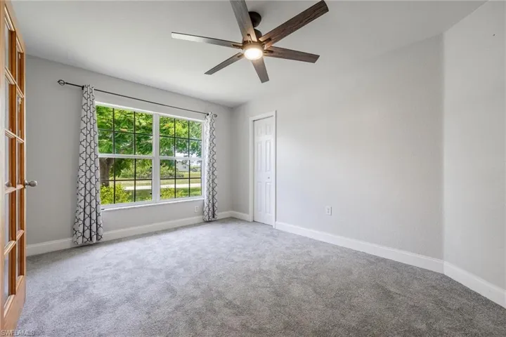 Unfurnished room featuring carpet and ceiling fan