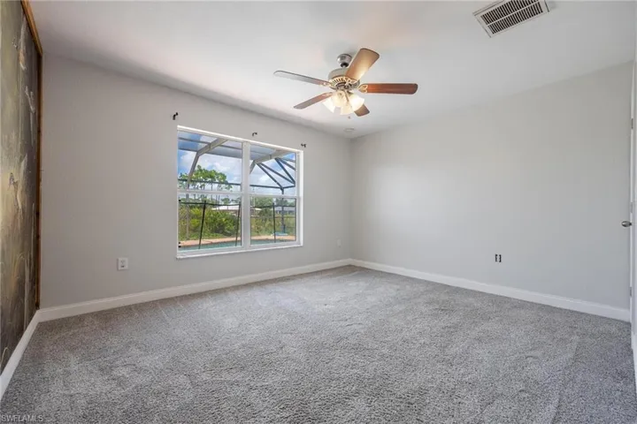 Spare room featuring carpet and ceiling fan
