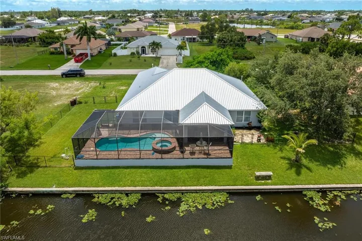 Birds eye view of property with a water view