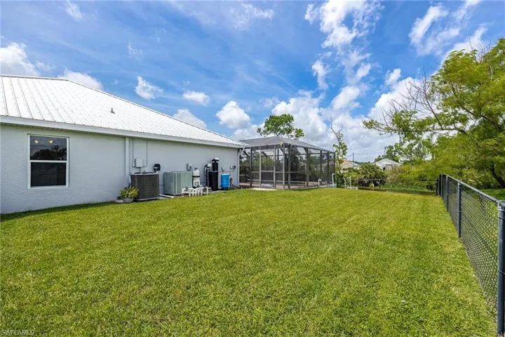 View of yard with glass enclosure and central AC unit