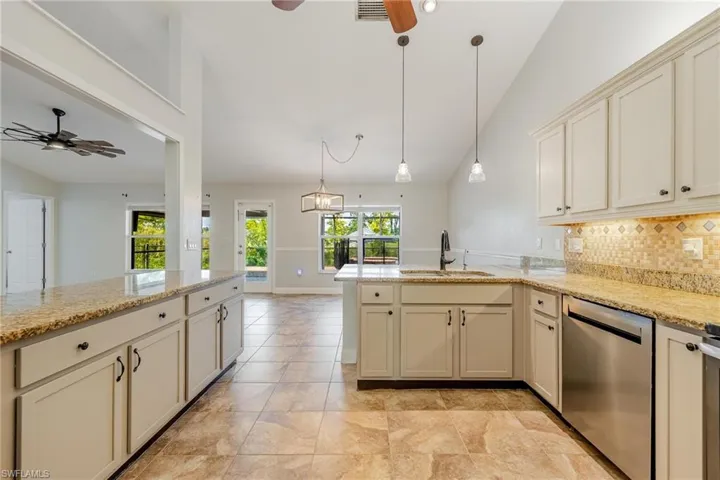Kitchen with sink, backsplash, light tile patterned floors, dishwasher, and ceiling fan