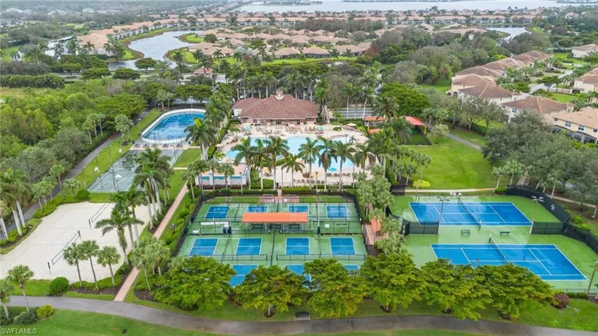 Aerial view of residential area featuring a nearby body of water and a pool area