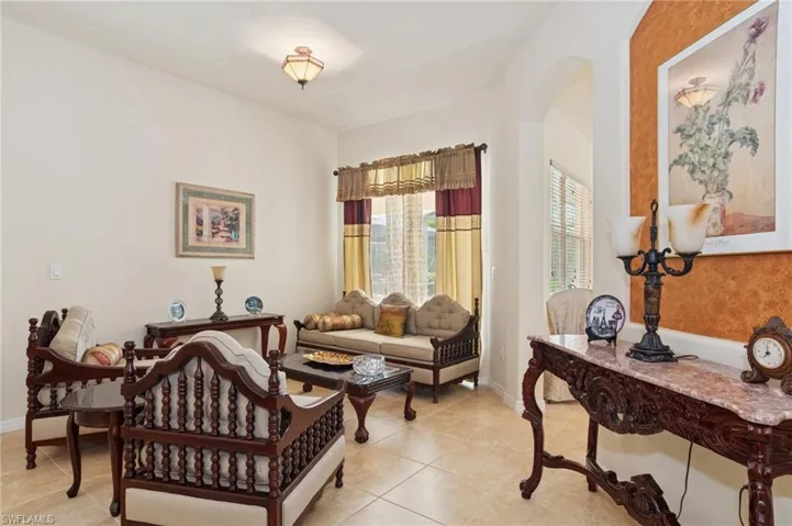 Living area featuring arched walkways and light tile patterned floors