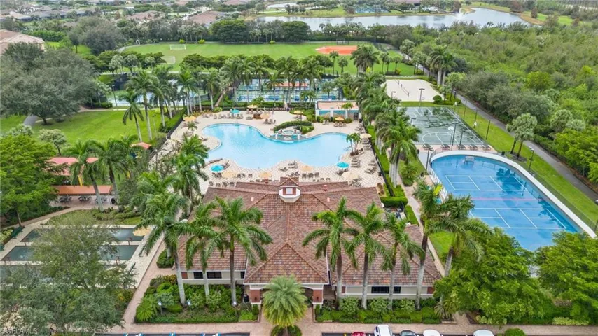 Drone / aerial view of a pool area and a nearby body of water