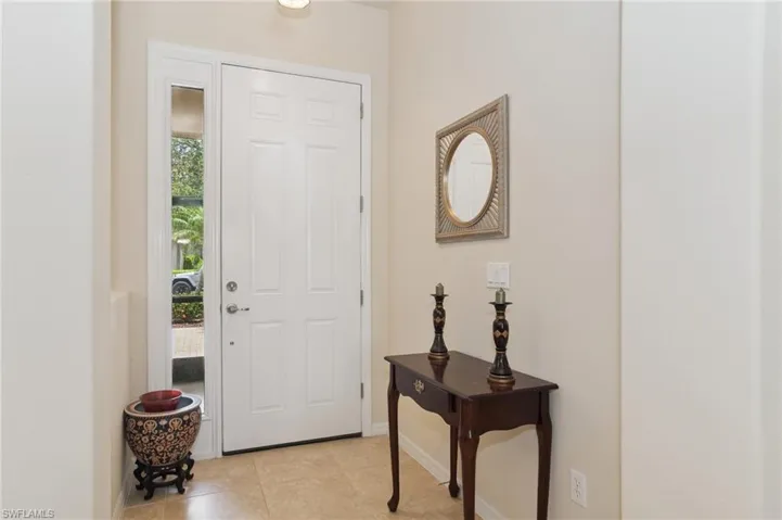 Entryway with baseboards and light tile patterned flooring