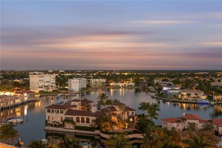 Aerial view at dusk featuring a water view