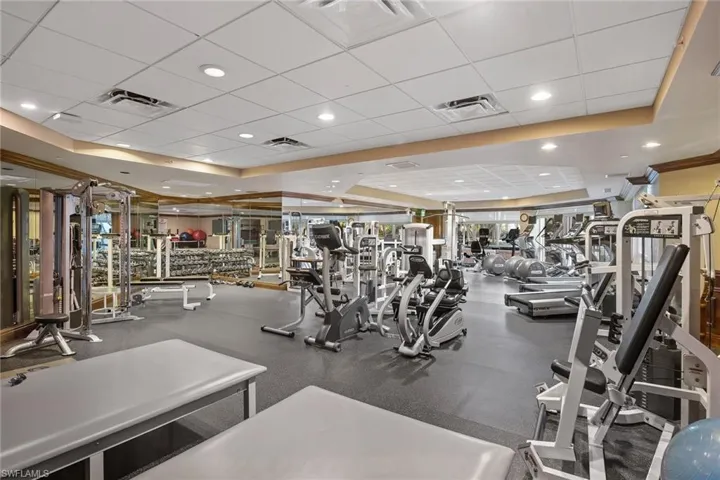 Exercise room with a paneled ceiling and a tray ceiling