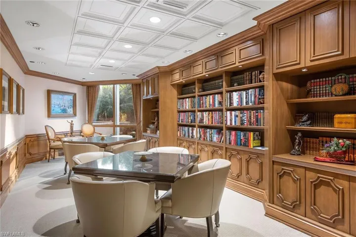 Sitting room with light colored carpet, ornamental molding, and built in features
