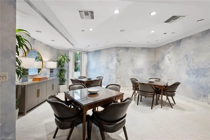 Dining room with crown molding and light carpet