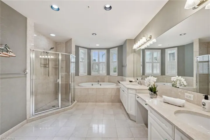 Bathroom with tile patterned flooring, shower with separate bathtub, and vanity