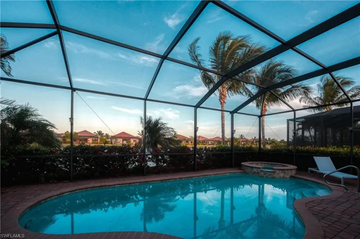The pool at dusk with a large spill-over hot tub.
