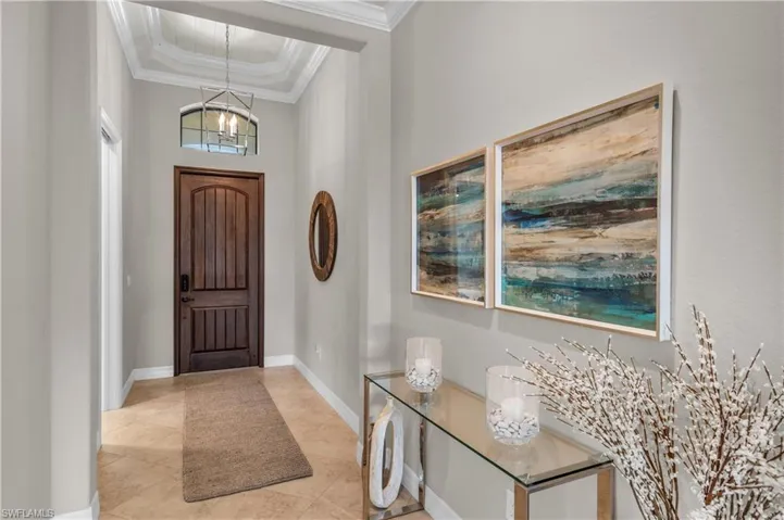 The foyer entrance features neutral tile laid on a diagonal which runs throughout home