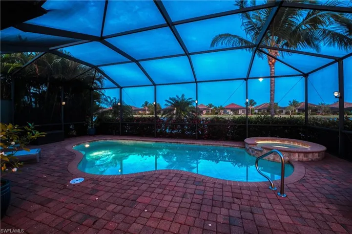 View of swimming pool with a patio, an in ground hot tub, and glass enclosure