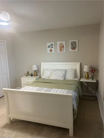 Bedroom with light tile patterned flooring and baseboards