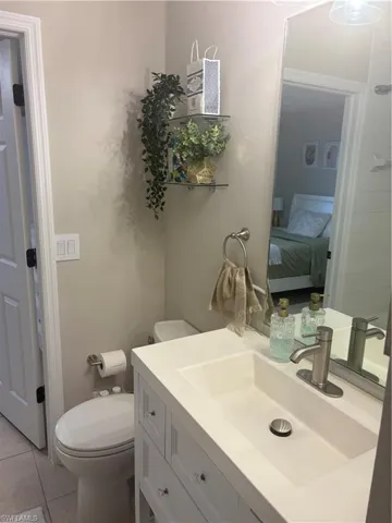 Ensuite bathroom with vanity and tile patterned floors