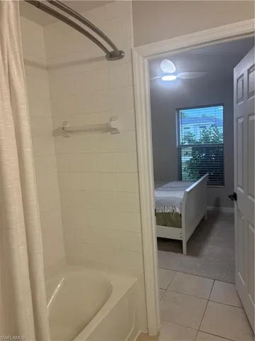 Ensuite bathroom featuring shower / bath combo and tile patterned floors