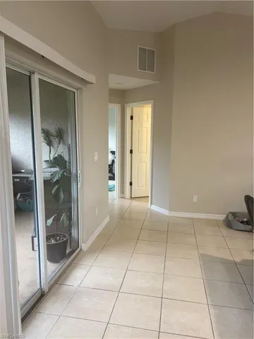 Empty room with light tile patterned floors and baseboards