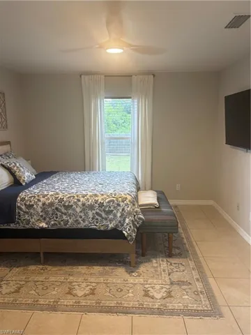 Bedroom featuring light tile patterned floors and ceiling fan