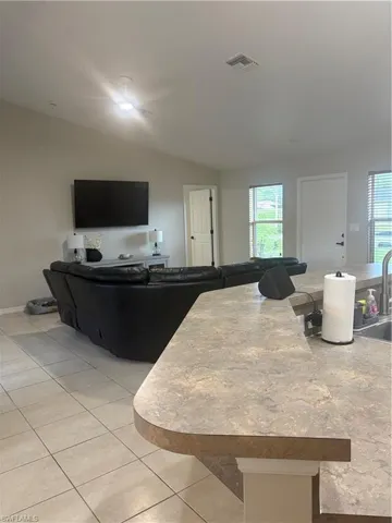 Living area featuring vaulted ceiling and light tile patterned floors
