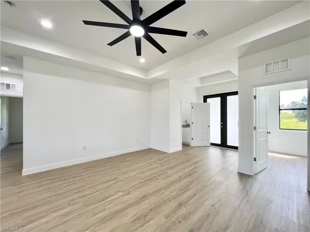Spare room with french doors, light wood-type flooring, and ceiling fan