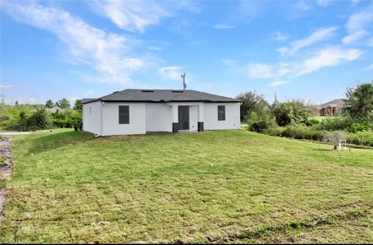 Back of house featuring a lawn
