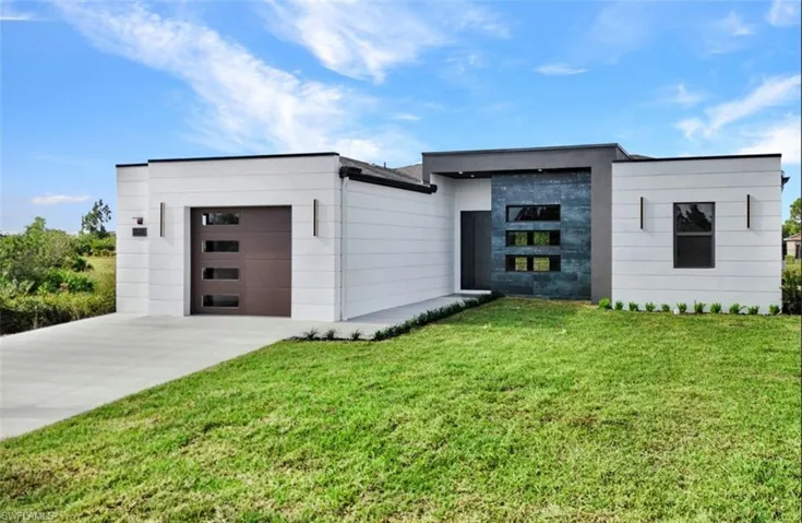 Modern home with a front lawn and a garage