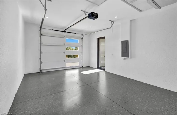 Garage featuring electric panel and a garage door opener