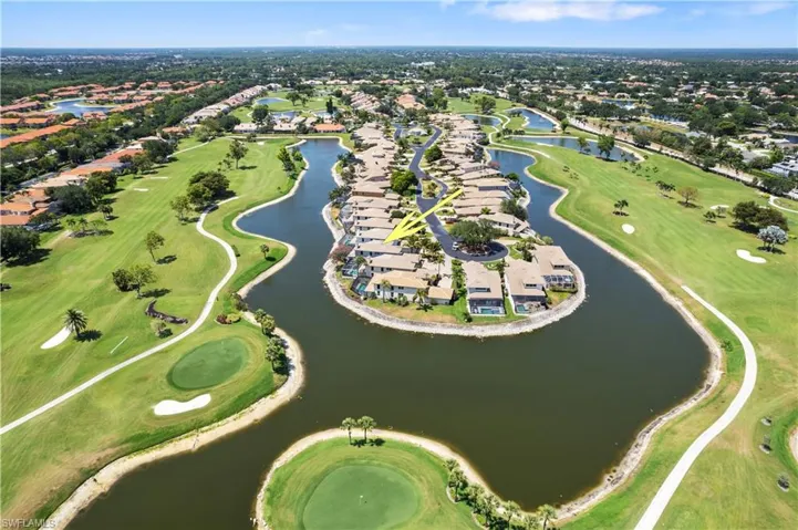 Aerial view of property's location featuring nearby suburban area, a nearby body of water, and a golf course