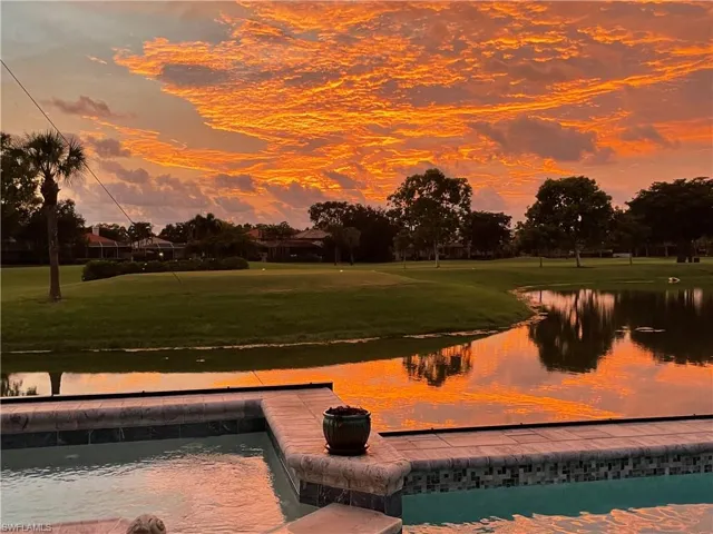 Surrounding community with a water view and a yard
