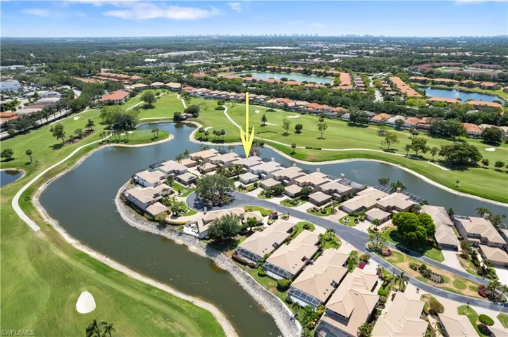 Aerial perspective of suburban area featuring a golf course and a large body of water