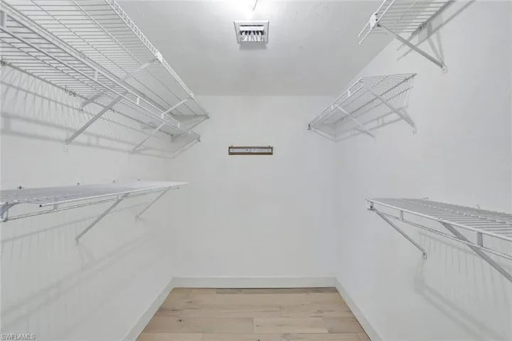 Walk in closet featuring wood flooring