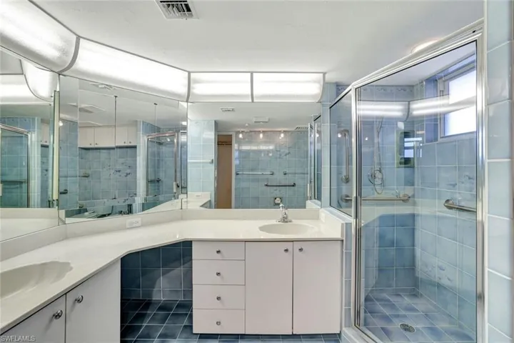 Double vanity, tile flooring, and a shower