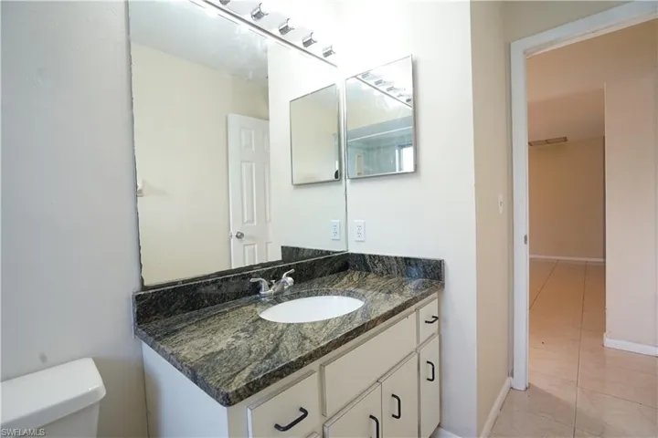 Half bathroom featuring vanity and light tile patterned floors
