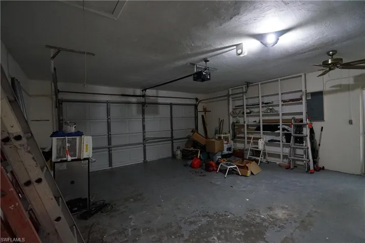 Garage with electric panel and a garage door opener