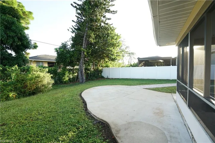 Fenced backyard featuring a patio and a sunroom