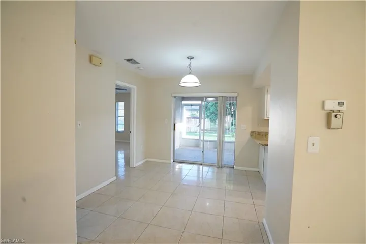 Unfurnished room featuring light tile patterned floors and baseboards