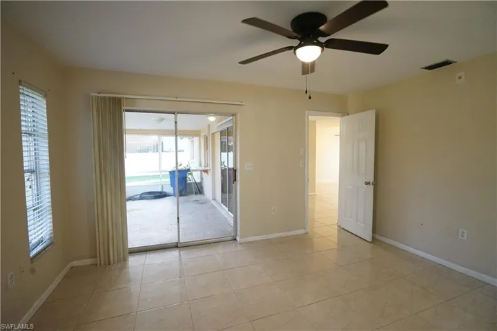 Empty room with light tile patterned flooring and ceiling fan