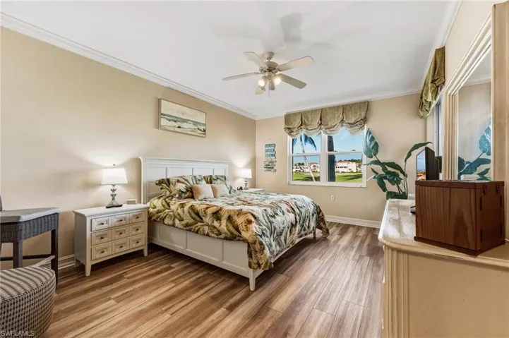 The generously sized primary bedroom offers direct access to the lanai, where natural light spills in and crown molding adds a refined touch—perfect for savoring morning coffee or unwinding with breathtaking sunset views.