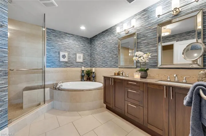 Bathroom with vanity, tile patterned flooring, plus walk in shower, and tile walls