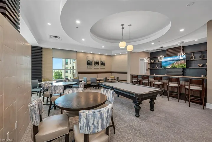 Playroom featuring a raised ceiling, carpet, indoor bar, and billiards